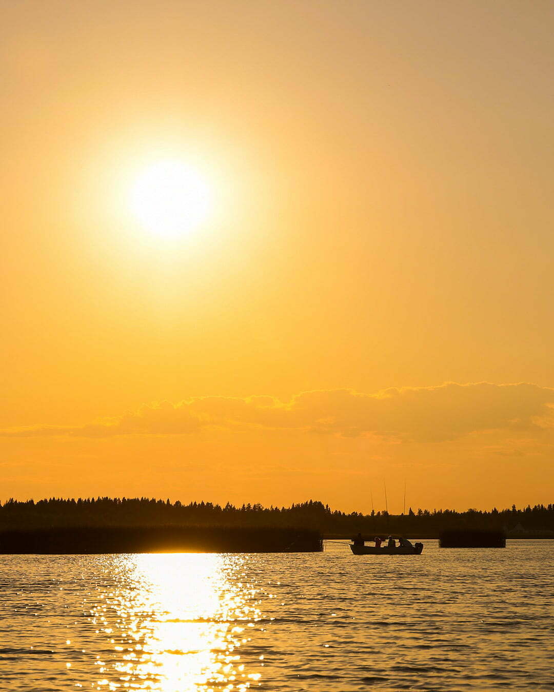 Liten fiskebåt i solnedgången vid Bensbyn i Luleå Skärgård